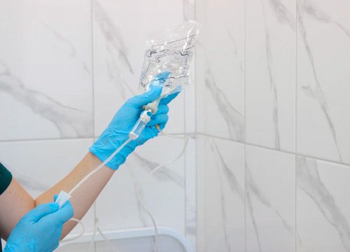 Врач готовит капельницу для пациента